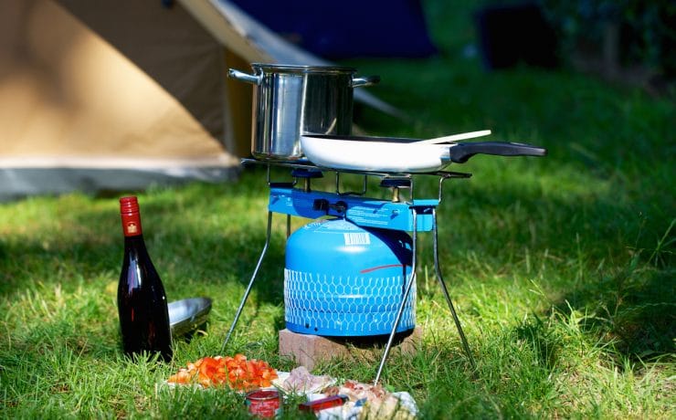 Family camping stove with gas canister and food on a camping trip