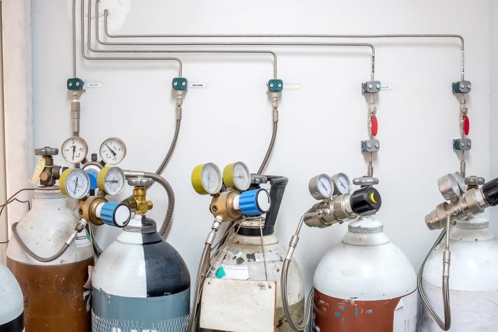 Valves of nitrogen, Helium, Oxygen ( Air Zero) tank and Gas Pressure Meter with Regulator for monitoring measure pressure production process in Chemistry Laboratory room