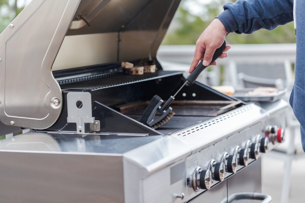 cleaning a bbq with brush