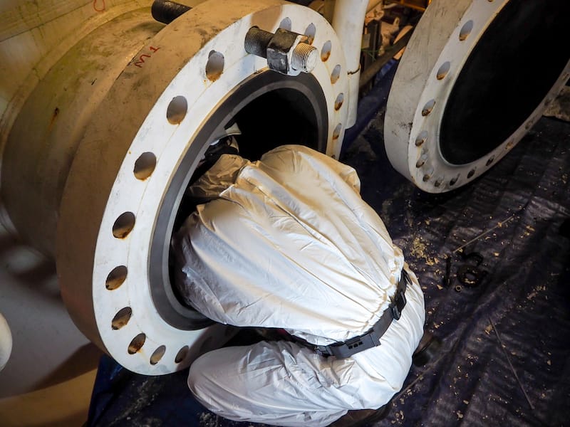 person welding inside pipe