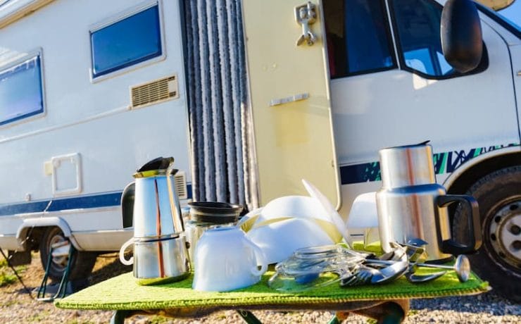 motorhome with a table set outside with tableware on
