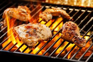 Pieces of chicken are cooking on top of a grill