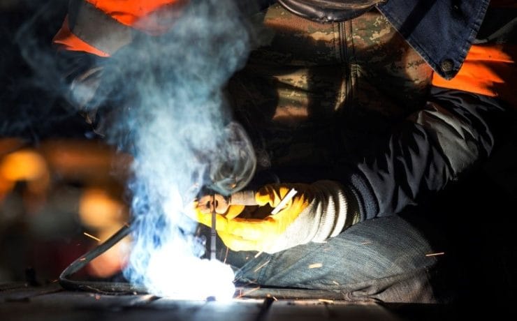 A person welding a metal piece