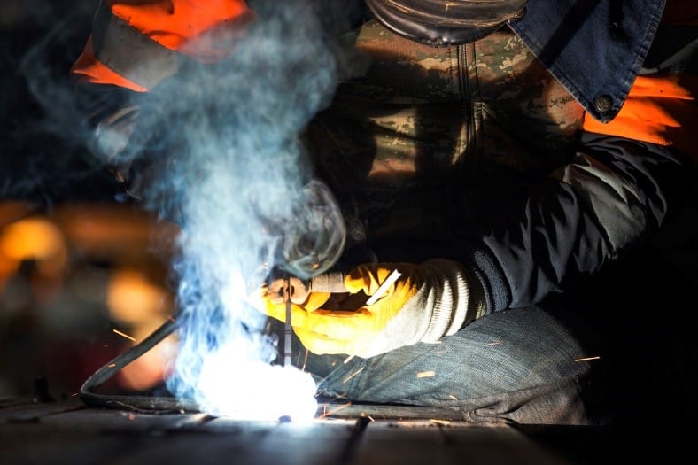 A person welding a metal piece