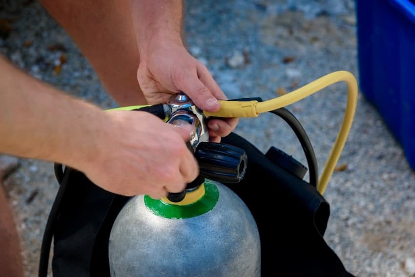 A person's hands holding a oxygen tank