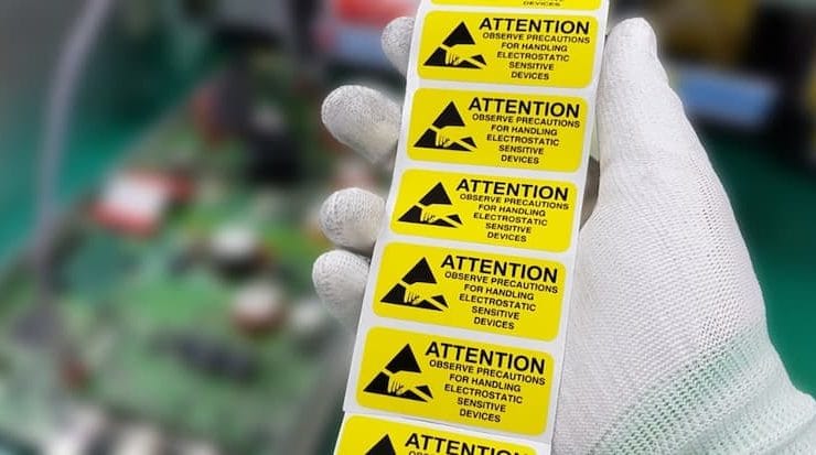 A hand holding a yellow label