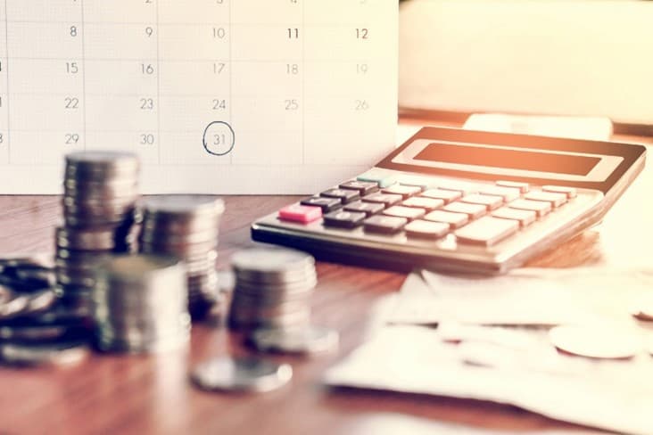 A calculator and coins on a desk