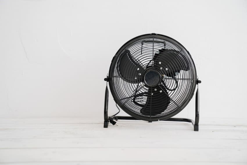 A black fan on a white surface