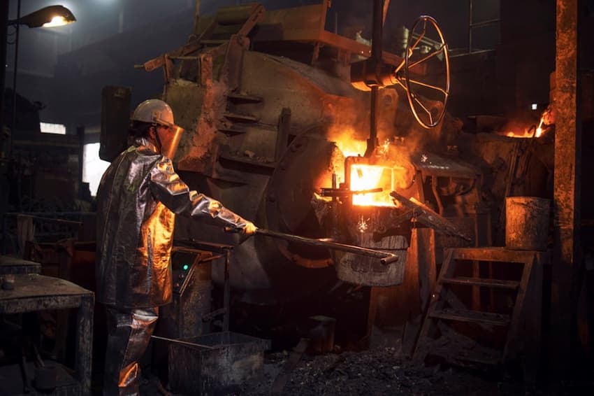 A person in a hard hat working in a factory