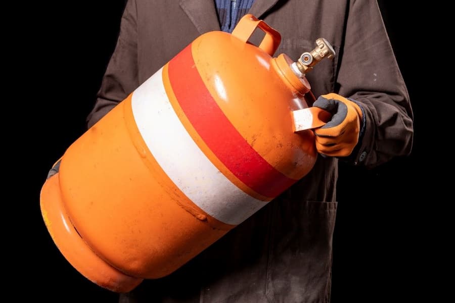 A person holding a propane tank