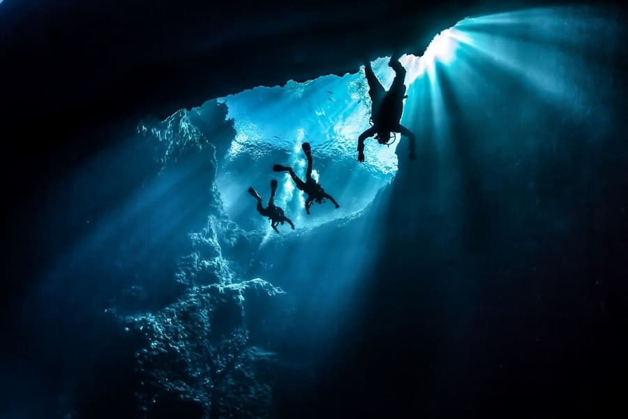 Scuba divers swimming in a cave