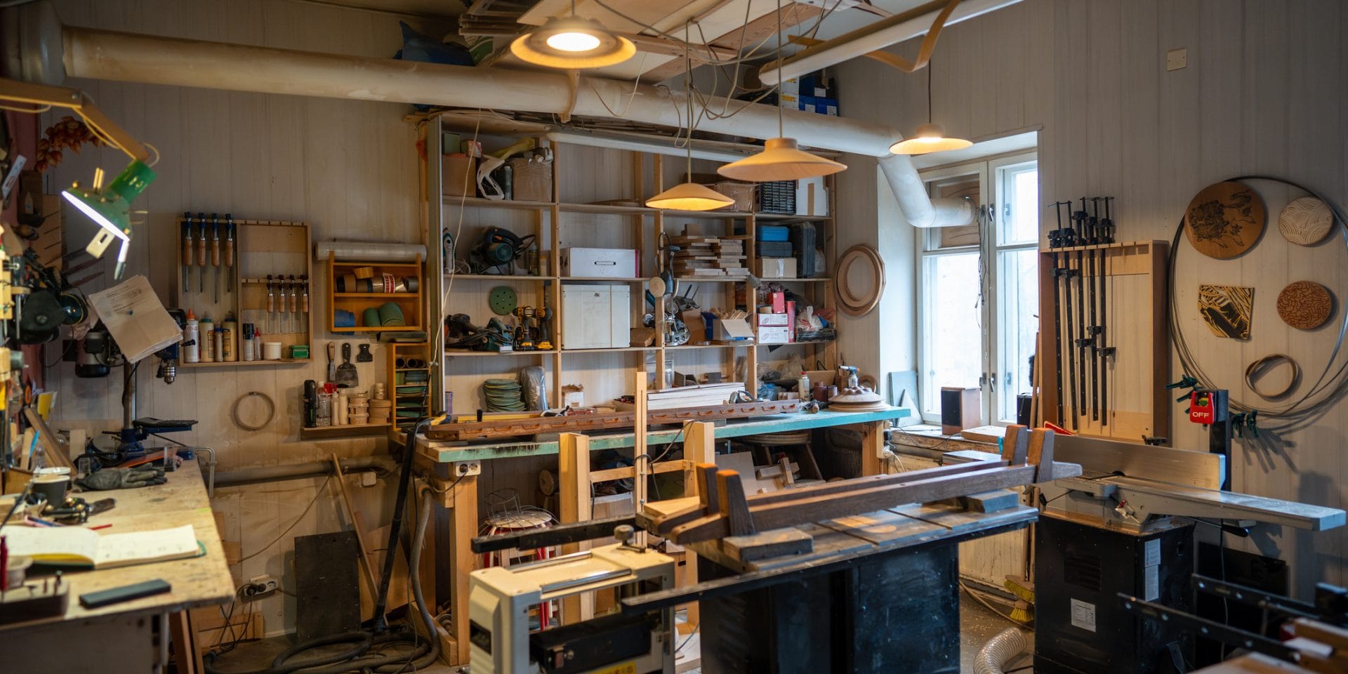 Organized tidy carpenter workplace for working with wooden products, making, creating furniture. Neat place for craftsman artisan to work with necessary accessories, tools, supplies, machines.