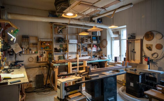 Organized tidy carpenter workplace for working with wooden products, making, creating furniture. Neat place for craftsman artisan to work with necessary accessories, tools, supplies, machines.